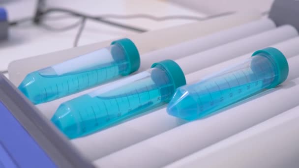 Mezclador de rodillos de tubo para mezclar, mezclar muestras biológicas en frascos de plástico — Vídeo de stock