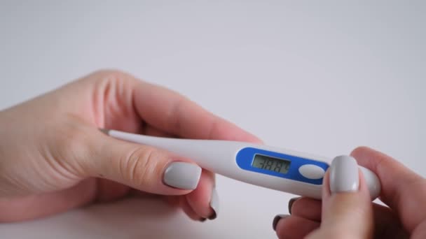 Gros plan : les mains de la femme tenant le thermomètre médical numérique à haute température — Video