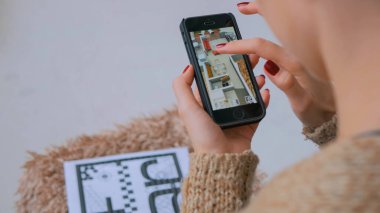 Artırılmış gerçeklik app ile akıllı telefon kullanan kadın sanal ev planı kontrol
