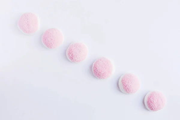 Een paar stukken van roze en witte snoep en gelei is op een witte bac — Stockfoto