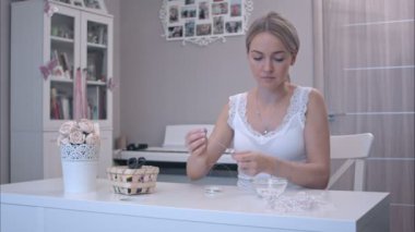 Genç kadın boncuklarını takı yapmak için malzeme çekme