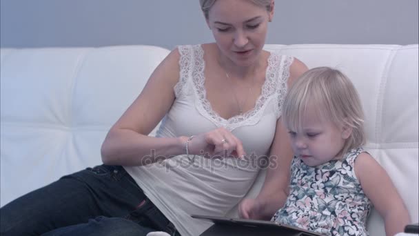 Mother teaching her baby child how to use tablet — Stock Video