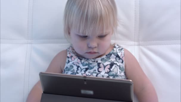 Ernstige babymeisje kijken naar Tablet PC — Stockvideo