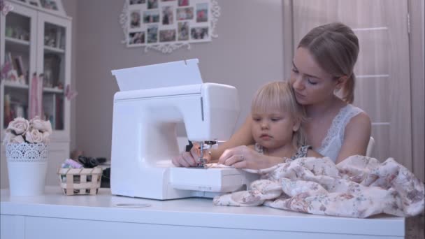 Мати навчає свою дівчинку, як користуватися швейною машиною — стокове відео