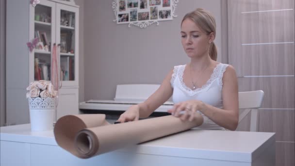 Jonge vrouw snijden inpakpapier — Stockvideo