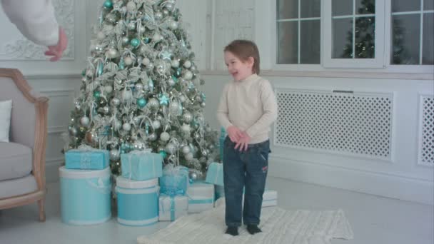 Отец и его счастливый сын выбирают рождественские подарки для открытия — стоковое видео
