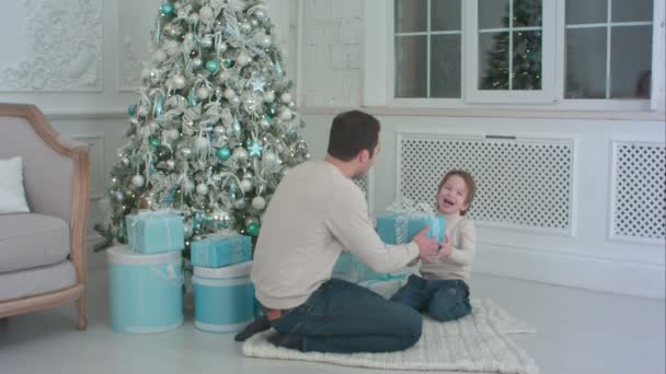 Feliz padre e hijo desenvolviendo un regalo sentado en el suelo — Vídeos de Stock