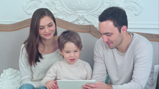 Familia feliz e hijo viendo la tableta en el sofá — Vídeos de Stock