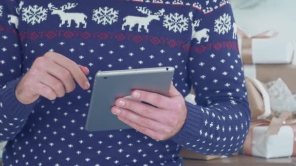 Young man in knit sweater with deers using tablet — Stock Video