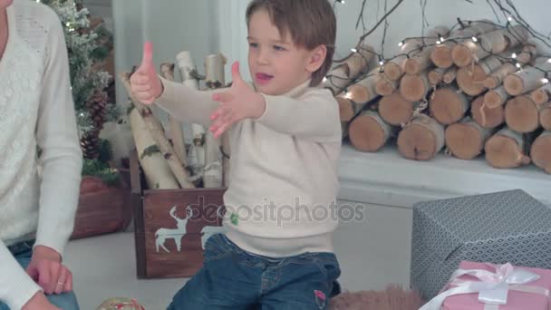 Jonge moeder en opgewonden jongen tellen Kerst presenteert op zijn vingers — Stockvideo
