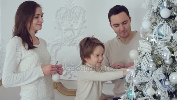 Glückliche Familie schmückt Weihnachtsbaum im Wohnzimmer — Stockvideo