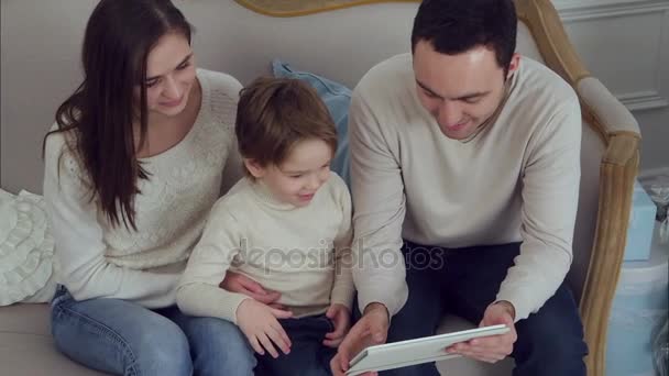 Família feliz de três assistindo vídeos engraçados no tablet — Vídeo de Stock