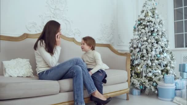 Jonge moeder praten op mobiele telefoon terwijl haar zoon stoeien — Stockvideo