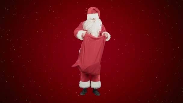 Real Santa Claus portant un grand sac plein de cadeaux sur fond rouge avec de la neige — Video