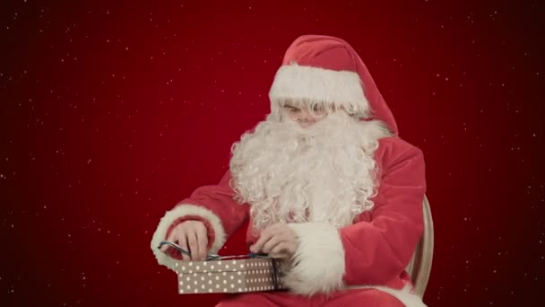 Santa Claus: Regalos alegres sobre fondo rojo con nieve — Vídeos de Stock