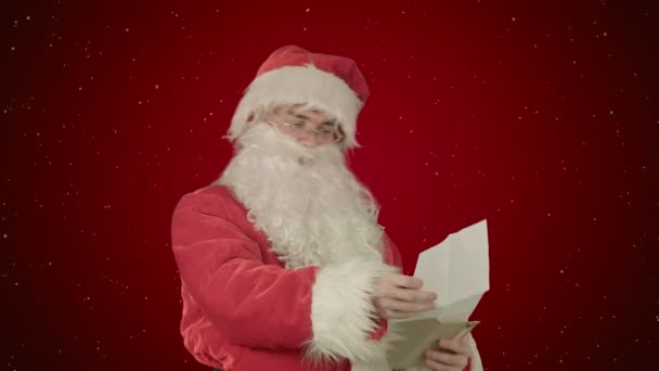 Santa Claus reading letters from children on red background with snow — Stock Video