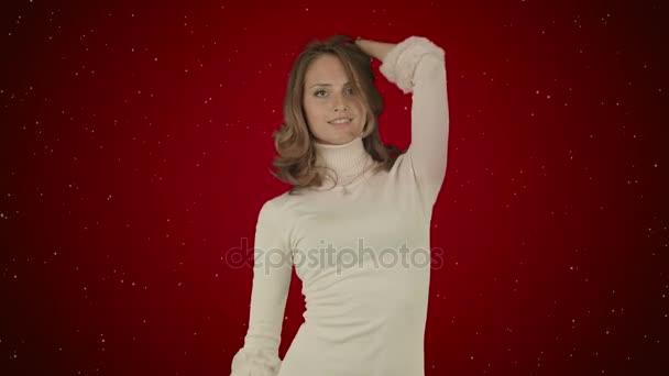 Красива жінка танцює на червоному тлі зі снігом — стокове відео