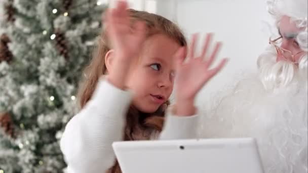 Santa with tablet listenting to a little girl describing presents she wants for Christmas — Stock Video