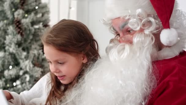 Weihnachtsmann und süßes kleines Mädchen machen Weihnachts-Selfies auf Tablet — Stockvideo