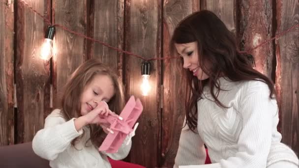 Mutlu anne ve kızı Xmas lights altında kanepede oturan oyuncaklar ile oynama — Stok video