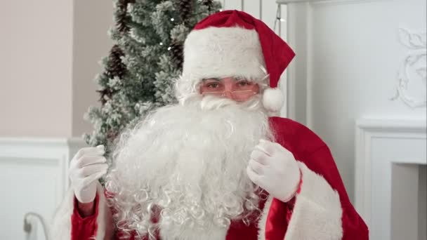 Санта-Клауса, потираючи бороду і говорити про Різдво, дивлячись на камеру — стокове відео