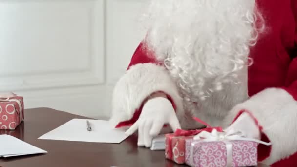 Santa Claus answering Christmas letters sitting at his table — Stock Video