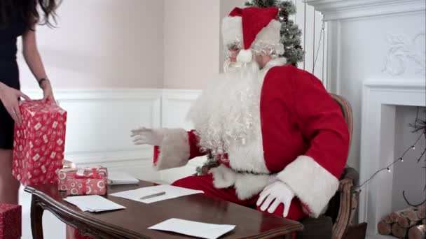 Ocupado Santa contestando chidlrens cartas mientras Santas pequeños ayudantes trayendo más regalos — Vídeo de stock