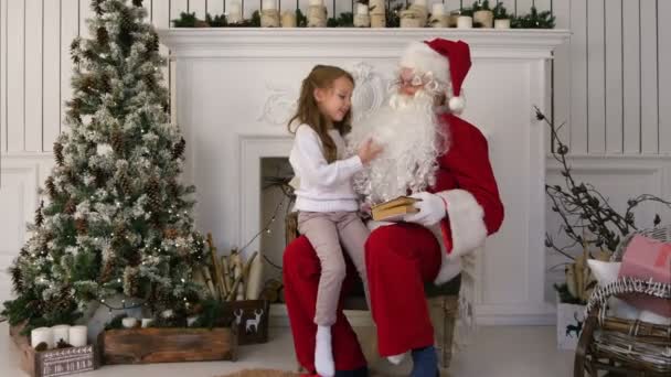 Überraschtes kleines Mädchen überprüft Weihnachtsmann-Bart — Stockvideo