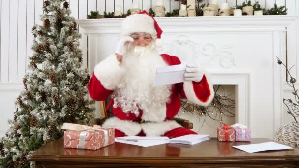 Weihnachtsmann sortiert Papierbriefe von Kindern — Stockvideo