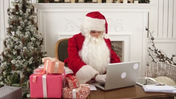 Moderne Kerstman bezig met zijn laptop en voorbereiding presenteert — Stockvideo