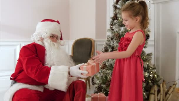 Papá Noel regalando a una niña sorprendida — Vídeo de stock