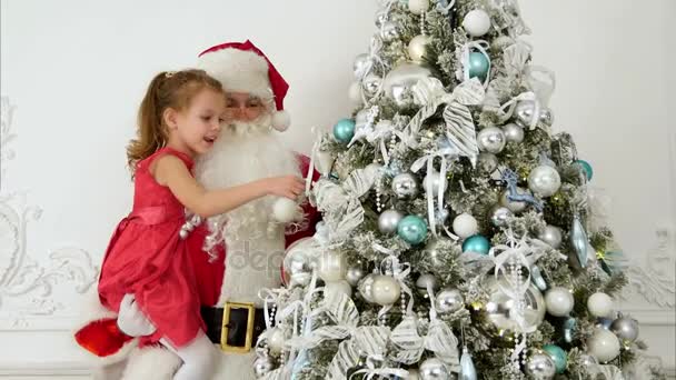 Papá Noel con niña bonita decorando el árbol de Navidad — Vídeos de Stock