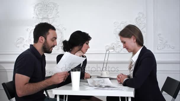 Семейная пара обсуждает что-то с дизайнером в офисе . — стоковое видео