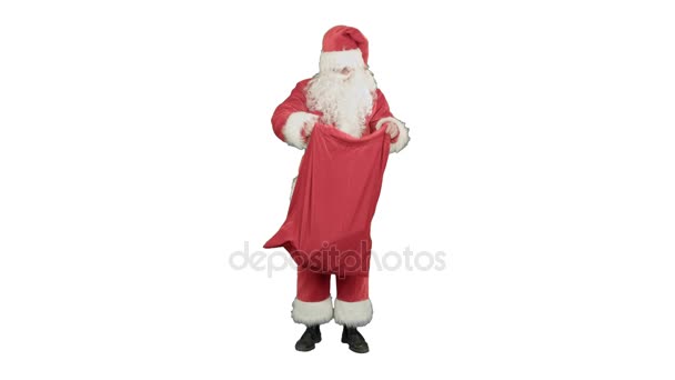 Real Santa Claus llevando una gran bolsa llena de regalos sobre fondo blanco — Vídeo de stock