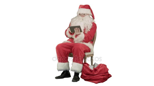 Santa Claus usando tableta para navegar por Internet y comunicarse en las redes sociales con los niños sobre fondo blanco — Vídeo de stock