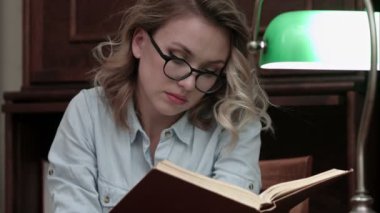 Ciddi genç kadın gözlük bilgilerini kitap arıyorum