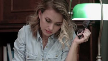 Genç kadın mutlu masasında oturmuş kitap okuma