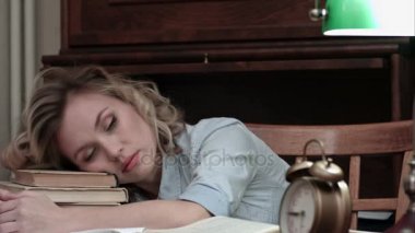 Onun masasında kitaplar üzerinde uyuya kalmış ve alarm tarafından uyandı güzel öğrenci
