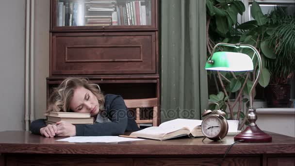 Donna esausta addormentata sulla pila di libri alla sua scrivania e svegliata da un allarme prende rapidamente i suoi libri e carte, beve caffè e se ne va — Video Stock