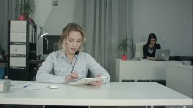 Çağrı Merkezi müşteri temsilcisi onun işyerinde dijital tablet kullanarak odaklı