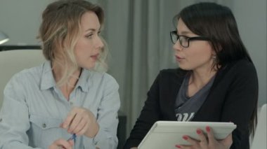 İki kadın arkadaşları ofiste tablet kullanarak beyin fırtınası