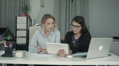 İki kadın profesyonel dijital tablet masa başında çalışırken kullanma