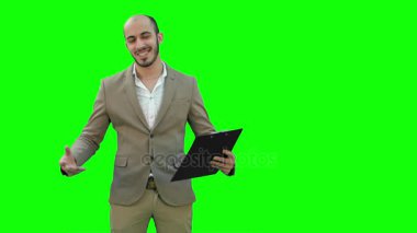 Gülümseyen genç adam iş sunumu Chroma anahtar yeşil ekran yapmak.