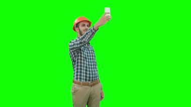 İnşaat işçisi kullanarak telefon selfies yeşil ekran üzerinde Chroma Key almak.