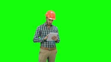Modern mühendis inşaat proje Chroma anahtar yeşil ekran üzerinde kontrol etmek için kablosuz tablet kullanma.