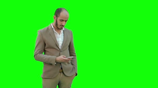 Drukke man in pak om tekstberichten te verzenden op de telefoon op een groen scherm, Chromakey. — Stockvideo