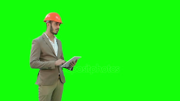 Engenheiro em capacete de segurança realizando inspeção com tablet em uma tela verde, Chroma Key . — Vídeo de Stock