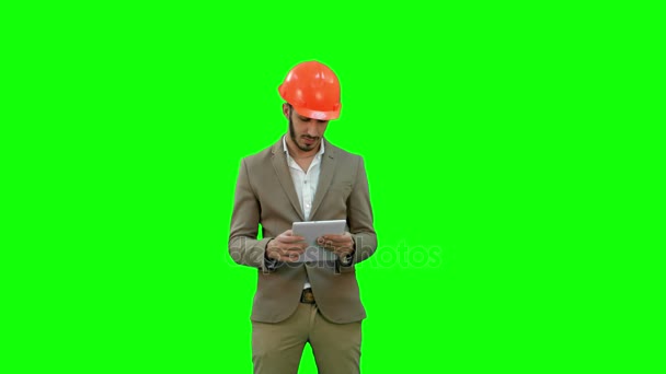 Jonge architect in helm bedrijf in Tablet PC- en weergegeven: duim op een groen scherm, Chromakey. — Stockvideo