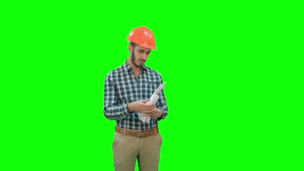 工程师在看建设计划在绿色屏幕，色度键上的安全帽. — 图库视频影像