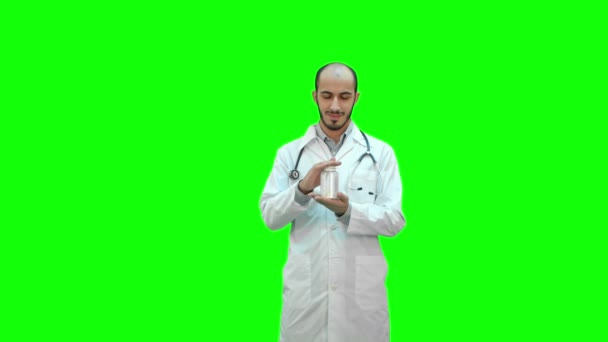 Usmívající se doktor doporučil pilulky a ukazuje palec na zelené obrazovce, Chroma Key. — Stock video